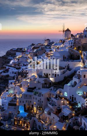 Sonnenaufgang über dem Dorf Oia auf der Insel Santorini. Berühmte weiße Häuser und Windmühlen. Stockfoto