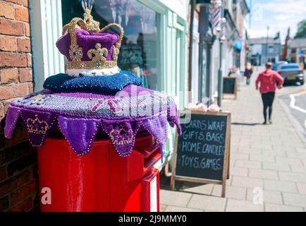 Mystery Knitter enthüllt den Platinum Jubilee Crown Postbox Topper in Syston, Leicester, Großbritannien. Dies ist die jüngste Kreation des Strickkünstlers, der als Syston Knitting Banxy bekannt ist. Stockfoto