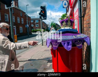 Mystery Knitter enthüllt den Platinum Jubilee Crown Postbox Topper in Syston, Leicester, Großbritannien. Dies ist die jüngste Kreation des Strickkünstlers, der als Syston Knitting Banxy bekannt ist. Stockfoto