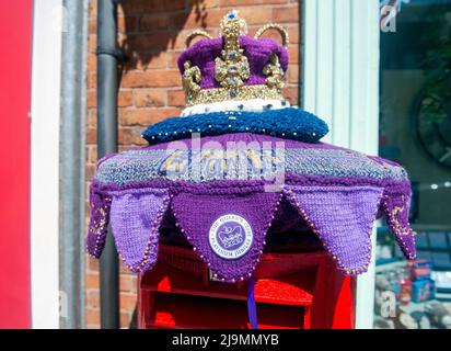 Mystery Knitter enthüllt den Platinum Jubilee Crown Postbox Topper in Syston, Leicester, Großbritannien. Dies ist die jüngste Kreation des Strickkünstlers, der als Syston Knitting Banxy bekannt ist. Stockfoto