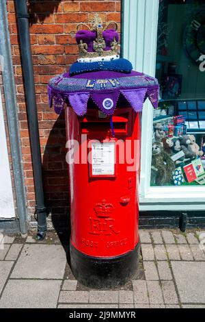 Mystery Knitter enthüllt den Platinum Jubilee Crown Postbox Topper in Syston, Leicester, Großbritannien. Dies ist die jüngste Kreation des Strickkünstlers, der als Syston Knitting Banxy bekannt ist. Stockfoto