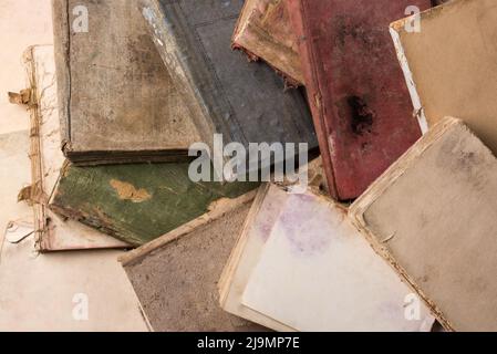 Stapel alter zerrissener Bücher, verfärbte und ruinierte Seiten, von oben genommen Stockfoto