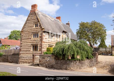 Schönes Strohhaus unter blauem Himmel im Dorf Blisworth in Northamptonshire, aufgenommen am 12.. Mai 2022. Stockfoto