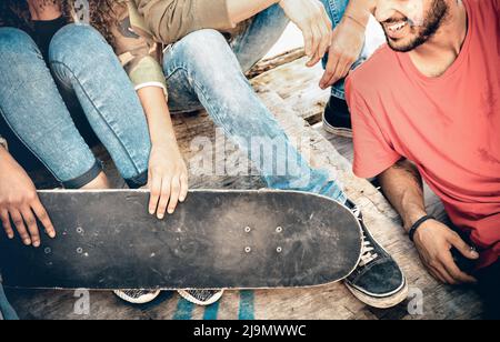 Gruppe von multirassischen Freunden, die Spaß haben und Zeit zusammen im Skateboard Park verbringen - Jugendfreundschaftskonzept mit jungen Menschen, die Skateboarder teilen Stockfoto