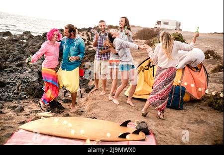 Hipster-Freunde, die gemeinsam auf der Strandparty auf Campingzeit Spaß haben - Wanderlust und alternatives Reisekonzept mit jungen Menschen, die tanzen und trinken Stockfoto