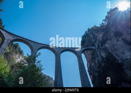 Die berühmte Landwasserviadukt-Kalksteinbrücke in der Nähe der Stadt Filisur im Kanton Graubünden, Schweiz. Stockfoto