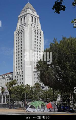 Los Angeles, CA / USA - 14. Mai 2022: Das historische Los Angeles Der Rathausturm ist gezeigt, mit Zelten eines Obdachlosen-Lagers auf dem Bürgersteig unten. Stockfoto