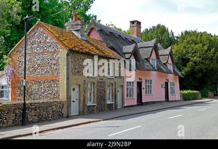 Ein Blick auf malerische Cottages, darunter das unter Denkmalschutz 2 stehende rosafarbene Church Cottage in Lavenham, Suffolk, England, Vereinigtes Königreich. Stockfoto