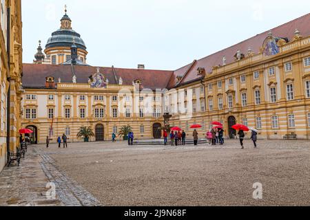 MELK, ÖSTERREICH - 12. MAI 2019: Dies ist der Prälaten-Hof mit Brunnen der Benediktinerabtei und unbenedete Besucher im Frühlingsregen. Stockfoto