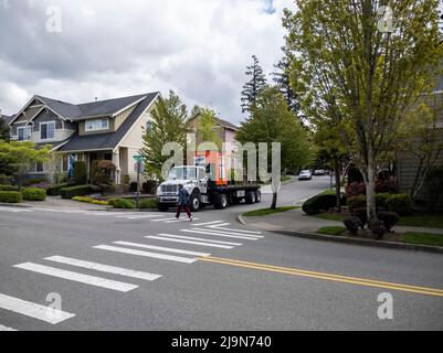 Mill Creek, WA USA - ca. Mai 2022: Abgewinkelte, weite Ansicht einer U-Box mit U-Haul auf einem Sattelschlepper in einem Wohnviertel. Stockfoto