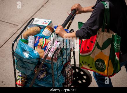 Eine Kundin mit einem Warenkorb, der mit ihrer Großzügigkeit von der Holy Apostles Food Pantry in Chelsea in New York am Dienstag, den 17. Mai 2022 gefüllt war. .(© Richard B. Levine) Stockfoto