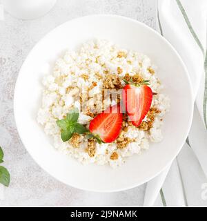 Käsehaus, Quark mit Müsli und frischer Erdbeere. Frühstück. Gesunde Ernährung, Ernährung. Draufsicht Stockfoto