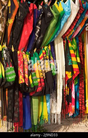 Bunte Auswahl an Strandkleider und Taschen zum Verkauf an einem tropischen Strand in Jamaika. Stockfoto