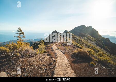 Wanderweg unter dem Berg Encumeada Baixa mit Ziel auf dem höchsten Berg Madeiras, dem Pico Ruivo. Die Sonne scheint auf der Seite des Madeira Stockfoto