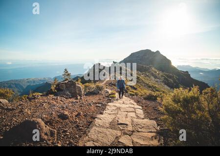 Wanderweg unter dem Berg Encumeada Baixa mit Ziel auf dem höchsten Berg Madeiras, dem Pico Ruivo. Die Sonne scheint auf der Seite des Madeira Stockfoto