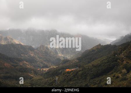 Blick von der Bergstraße auf die Stadt Serra de Agua eingebettet in nebliges Wetter in der Mitte der Insel Madeira, Portugal. Natur pur surro Stockfoto