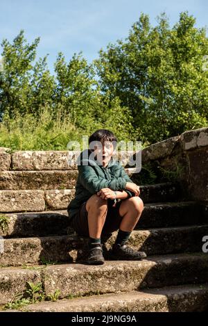 Kleiner Junge, der auf einer Steintreppe in spanien sitzt Stockfoto