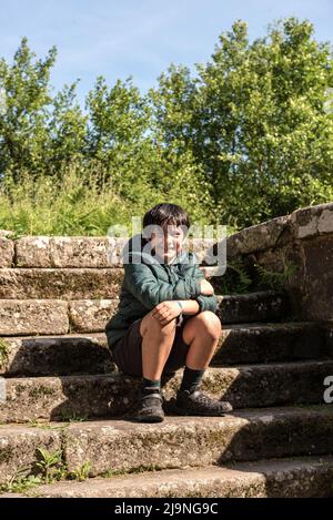 Kleiner Junge, der auf einer Steintreppe in spanien sitzt Stockfoto