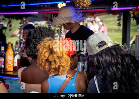 Afro-Mädchen bestellen in einer tropischen Outdoor-Bar in Madrid Stockfoto