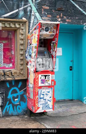 Eine Collage aus Aufklebern, Tags, Hinweisen und Graffiti auf einem Geldautomaten im Freien an der Wycoff Avenue in Bushwick, Brooklyn, der Outdoor-Kunsthauptstadt von NYC. Stockfoto