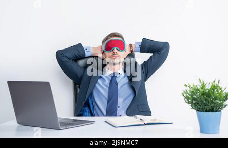 Müde Chef entspannen in Schlafmaske am Arbeitsplatz Stockfoto