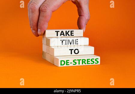 Nehmen Sie sich Zeit, um das Symbol zu entspannungsfrei zu machen. Konzeptwörter nehmen sich Zeit, um auf Holzklötzen Stress abzubauen. Schöne orange Tisch orange Hintergrund. Psychologisches Geschäft Stockfoto