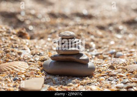 Steinpyramide an einem Sandstrand, selektiver Fokus. Entspannung und Balance. Stockfoto