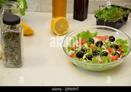 Gesunder Salat in einer Schüssel mit Oliven, Radgerichten, Tomaten, Käse und magerem Schinken zum Frühstück serviert. Gesundes, leckeres Essen mit Vitaminen, vegetarisch Stockfoto