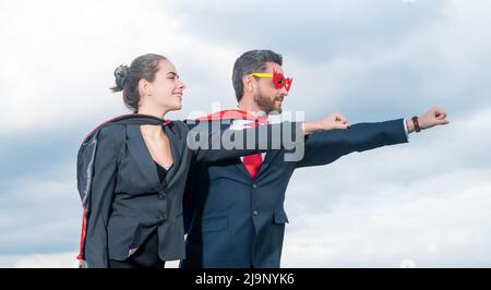 Business-Paar in Superhelden-Anzug auf Himmel Hintergrund. Superpower Stockfoto