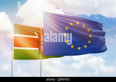 Sonniger blauer Himmel und Flaggen der europäischen Union und kenias Stockfoto