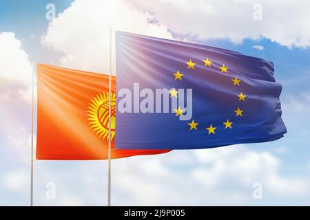 Sonniger blauer Himmel und Flaggen der europäischen Union und kirgisistans Stockfoto