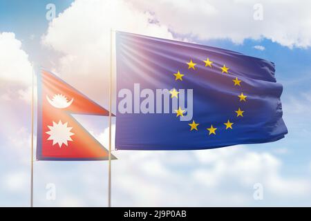 Sonniger blauer Himmel und Flaggen der europäischen Union und nepals Stockfoto