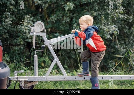 Ein agiles Kind Sport auf einem Bootsanhänger Mechanismus in der Natur. Stockfoto