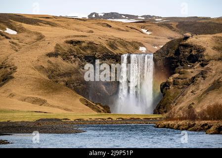 Fernansicht des mächtigen Skógafoss-Wasserfalls, von der Route 1 / Ringstraße über das Wasser des Flusses Skóga, Südregion, Island Stockfoto
