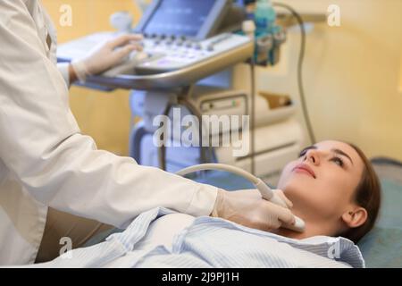 Junge Frau bekommt Schilddrüse Ultraschalluntersuchung in der modernen Klinik Stockfoto