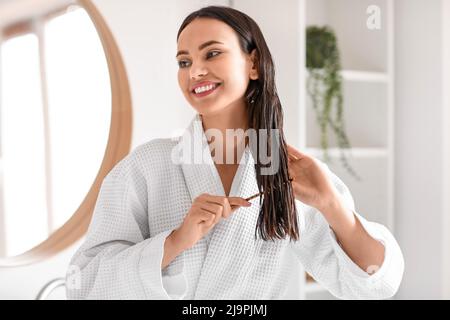 Junge Frau, Bürsten ihr Haar im Bad Stockfoto