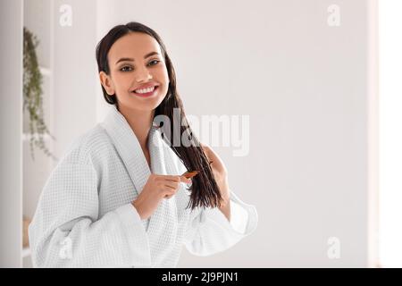 Junge Frau, Bürsten ihr Haar im Bad Stockfoto