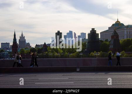 Moskau, Russland. 20.. Mai 2022. Fußgänger laufen gegen die Skyline von Moskau. Am Horizont sind Kremltürme, der große Kremlpalast, das Geschäftszentrum der Stadt Moskau und die Moskauer Staatliche Universität zu sehen. (Bild: © Vlad Karkov/SOPA Images via ZUMA Press Wire) Stockfoto