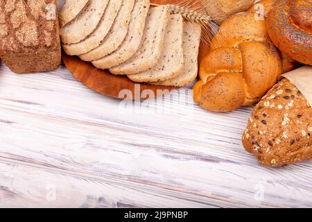 Zusammensetzung mit Brot mit knuspriger Kruste, Brötchen auf weißem Hintergrund. Stockfoto