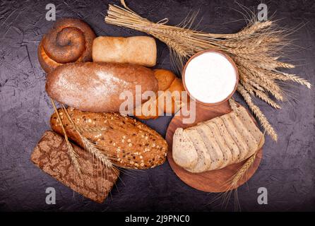 Weißbrot und Roggenbrot, Brötchen und Creme aus der Nähe. Zusammensetzung mit Broten. Stockfoto