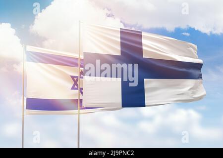 Sonniger blauer Himmel und Flaggen von finnland und israel Stockfoto