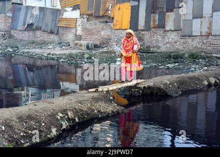 Dhaka, Bangladesch. 12. August 2020. Eine Frau trägt einen Wasserkrug, nachdem sie Wasser aus einem gemeinsamen Wasserhahn in einem Slum gesammelt hat, da es keine direkte Wasserleitung zu ihrem Tierheim in Dhaka gibt. (Foto von Piyas Biswas/SOPA Images/Sipa USA) Quelle: SIPA USA/Alamy Live News Stockfoto