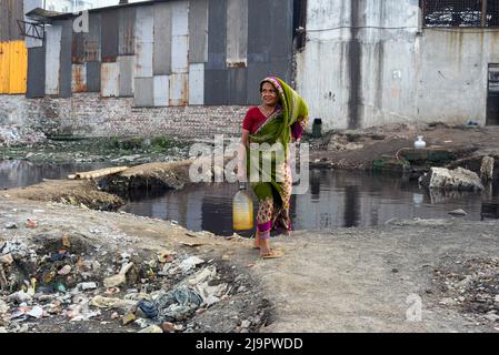 Dhaka, Bangladesch. 12. August 2020. Eine Frau trägt eine Flasche Wasser, nachdem sie Wasser aus einem gemeinsamen Wasserhahn in einem Slum gesammelt hat, da es keine direkte Wasserleitung zu ihrem Tierheim in Dhaka gibt. (Foto von Piyas Biswas/SOPA Images/Sipa USA) Quelle: SIPA USA/Alamy Live News Stockfoto