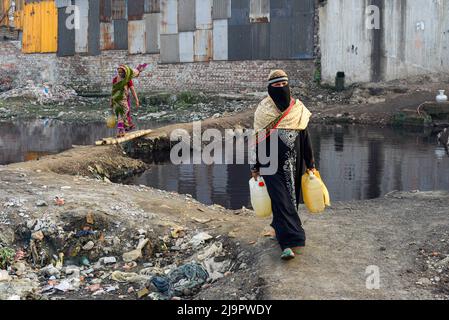 Dhaka, Bangladesch. 12. August 2020. Eine Frau trägt Kanister mit Wasser, nachdem sie Wasser aus einem gemeinsamen Wasserhahn in einem Slum gesammelt hat, da es keine direkte Wasserleitung zu ihrem Tierheim in Dhaka gibt. (Foto von Piyas Biswas/SOPA Images/Sipa USA) Quelle: SIPA USA/Alamy Live News Stockfoto