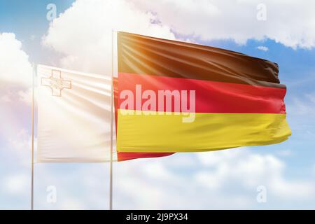 Sonniger blauer Himmel und Flaggen von deutschland und malta Stockfoto