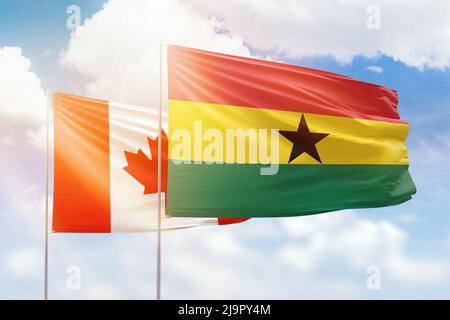 Sonniger blauer Himmel und Flaggen von ghana und kanada Stockfoto