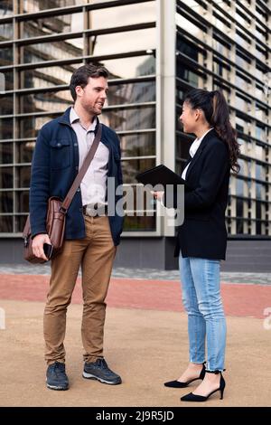 Geschäftsmann und -Frau vor dem Bürogebäude Stockfoto