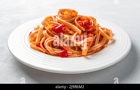 Pasta mit traditioneller Tomatensauce auf grauem Hintergrund. Pasta mit Gemüsesauce. Stockfoto