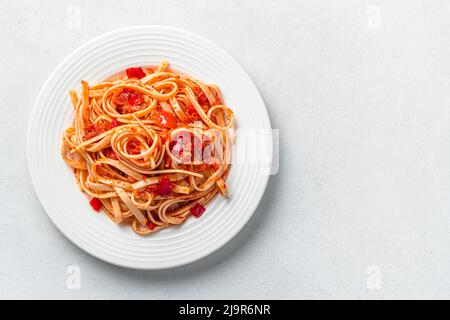Pasta mit Tomaten und frischem Basilikum auf hellem Hintergrund. Stockfoto