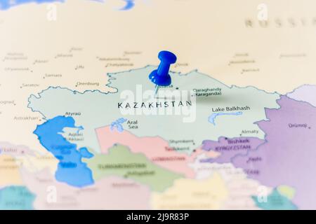 Blauer Stecknadel, der auf einer politischen Weltkarte auf Kasachstan zeigt Stockfoto